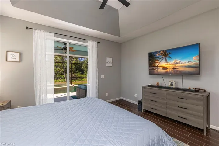 Bedroom featuring wood finish floors, ceiling fan, access to outside, and lofted ceiling