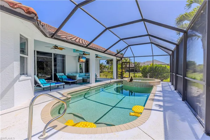 Combined pool / hot tub featuring outdoor lounge area, a sunroom, a patio area, and glass enclosure