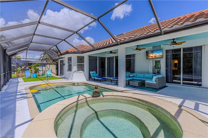 Relaxing pool / spa with a sunroom, a lanai, a patio, and outdoor furniture