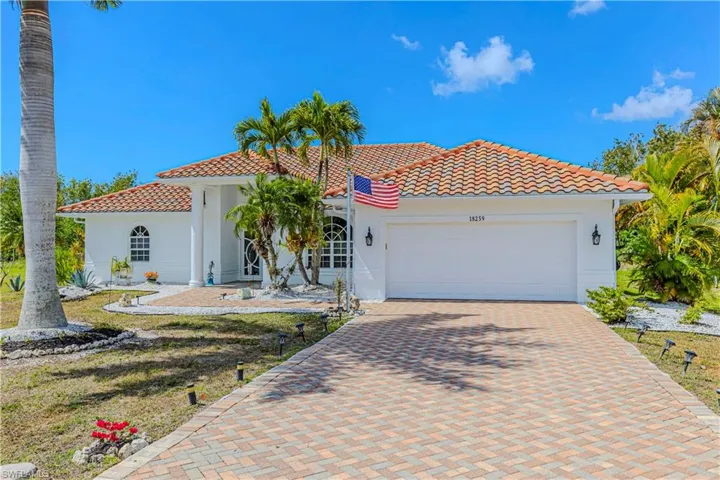 Mediterranean / spanish home with decorative driveway, a garage, stucco siding, and a tile roof
