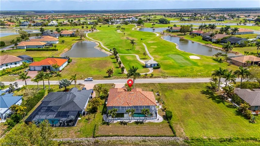 Aerial view of residential area with a nearby body of water and a golf club