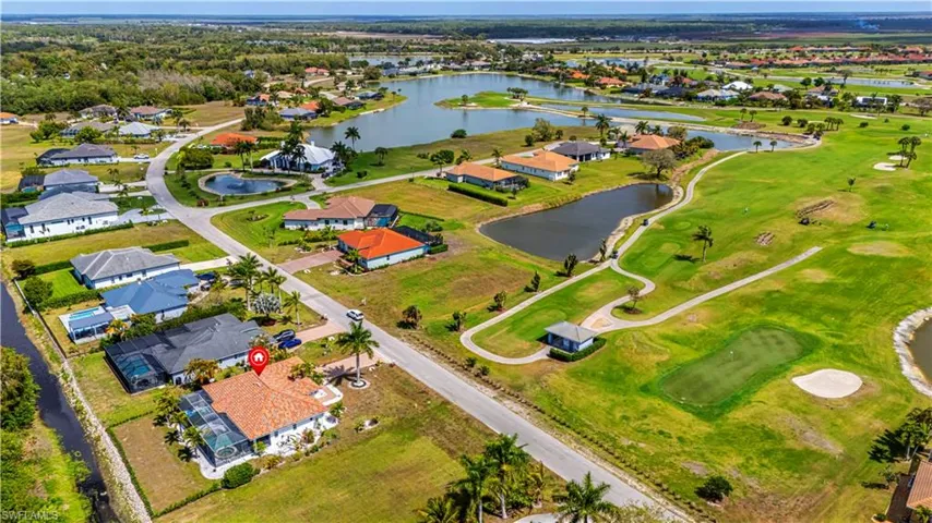 View of property location featuring nearby suburban area, a large body of water, and a local golf course