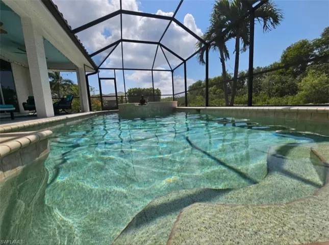Swimming pool featuring glass enclosure, a sunroom, and a patio