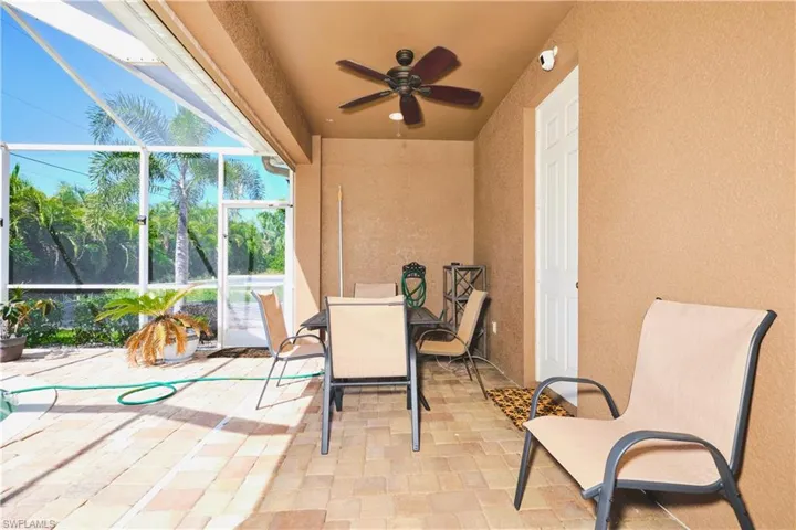 View of patio / terrace featuring a sunroom, a lanai, outdoor dining area, and ceiling fan