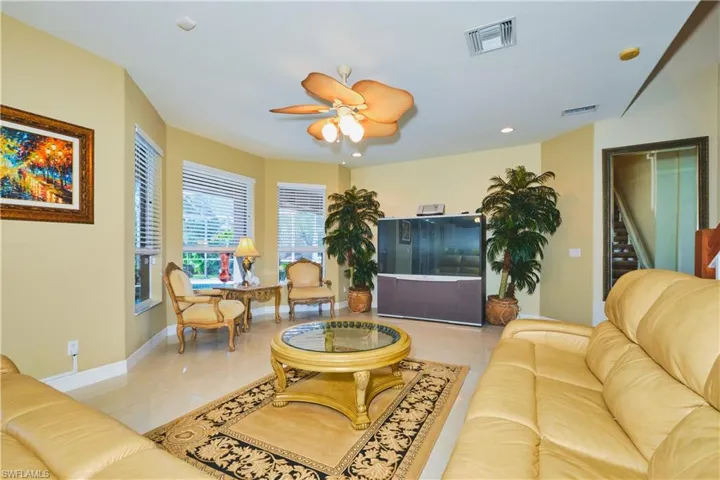 Living room featuring ceiling fan, light tile patterned floors, and recessed lighting