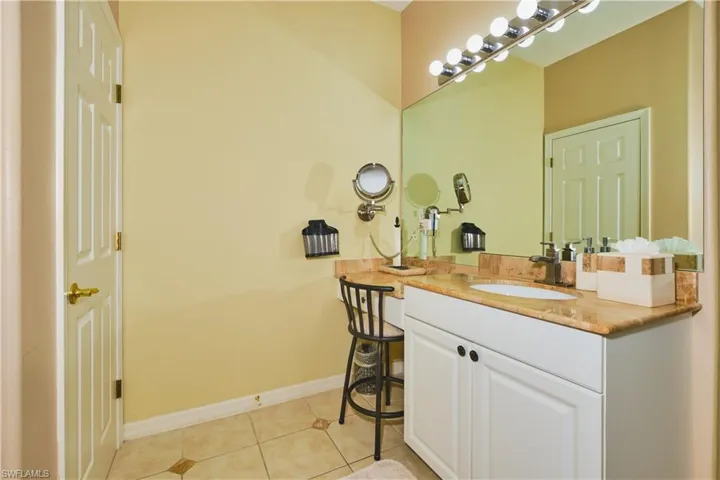 Bathroom with light tile patterned floors and vanity