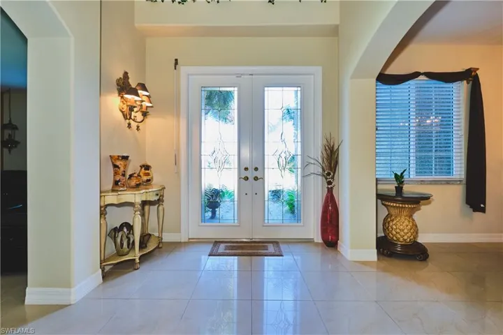 Tiled entryway featuring arched walkways and french doors