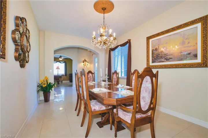 Dining area featuring arched walkways, plenty of natural light, a chandelier, and light tile patterned floors