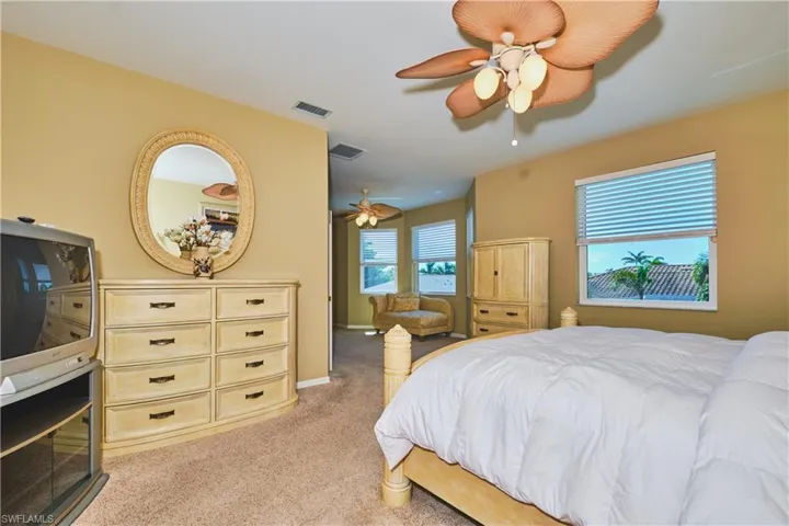 Bedroom with light colored carpet and a ceiling fan