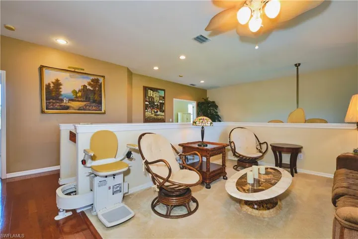 Living area with recessed lighting, wood finished floors, and ceiling fan