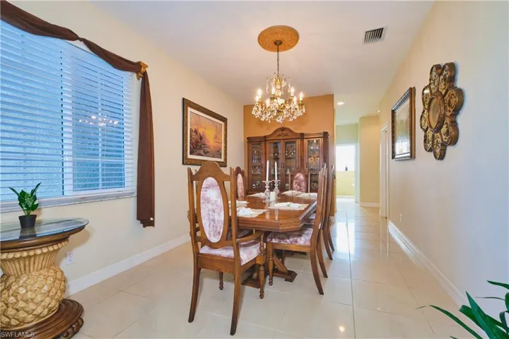Dining space featuring light tile patterned flooring, a chandelier, and recessed lighting