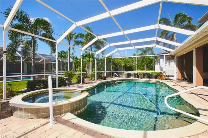 View of swimming pool with a patio area, a sunroom, and a pool with connected hot tub