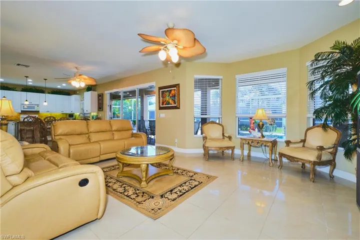 Living area featuring light tile patterned floors, a ceiling fan, and recessed lighting