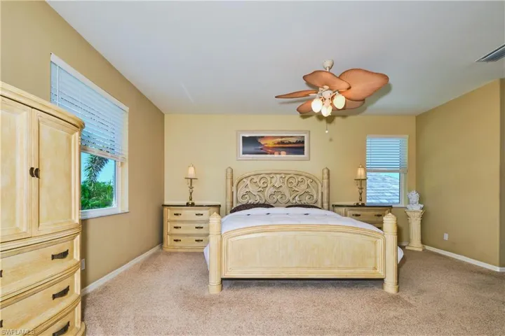 Bedroom with light colored carpet and ceiling fan