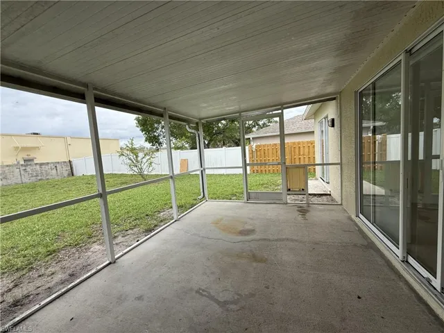 Screened concrete patio featuring multiple sliding glass door access points