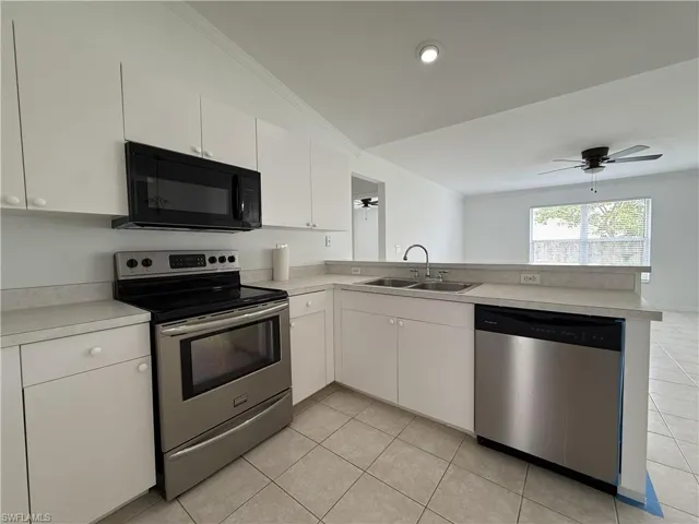 Kitchen with white cabinetry, light-toned countertops, and tile flooring