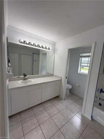 Bathroom vanity featuring a single basin sink, laminate countertop, and ample under-cabinet storage