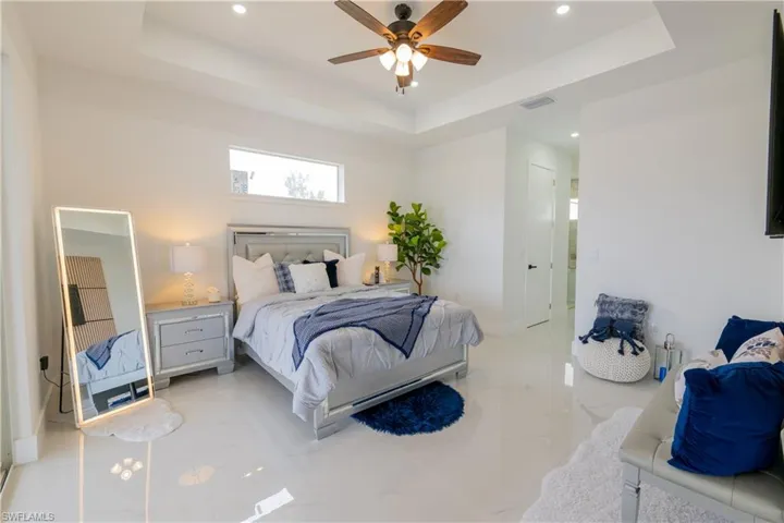 Bedroom with a tray ceiling, a ceiling fan, recessed lighting, and a closet