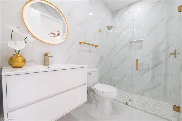 Full bath with vanity and a marble finish shower