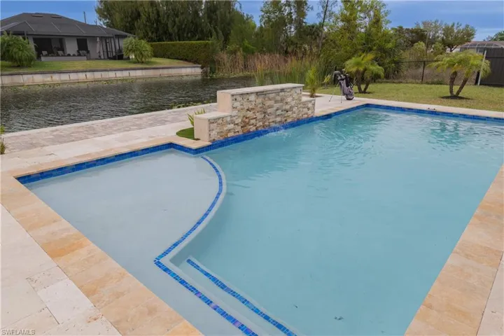 View of pool featuring patio surround and a water view