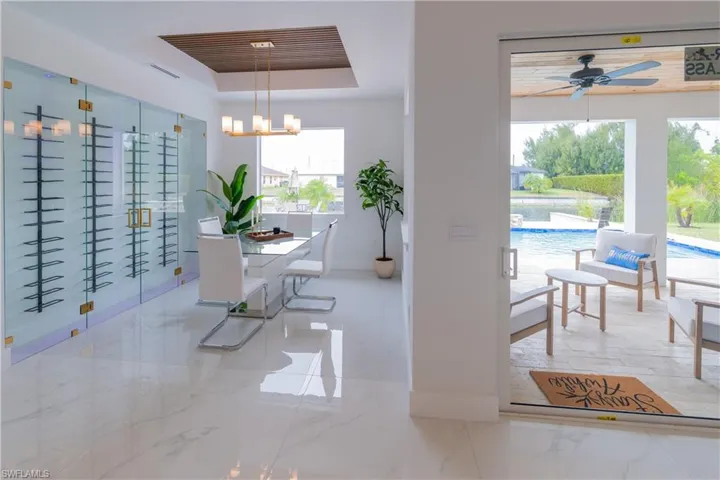 Dining space with a raised ceiling, a chandelier, and ceiling fan