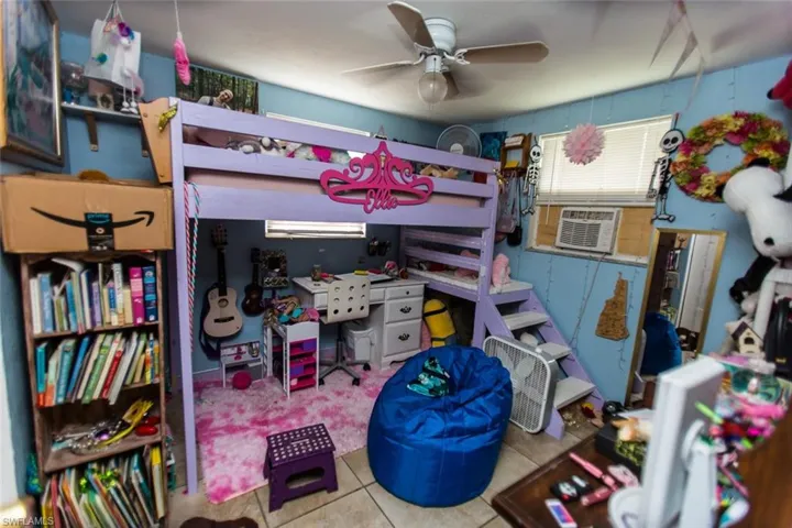 Bedroom with tile patterned flooring, cooling unit, and ceiling fan