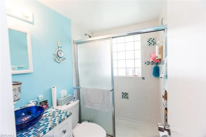 Bathroom with vanity, walk in shower, and toilet