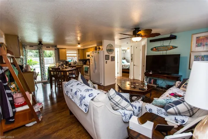 Living room featuring a textured ceiling, dark hardwood / wood-style flooring, and ceiling fan