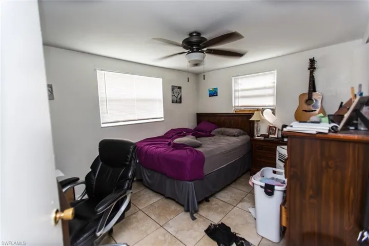 Bedroom with light tile patterned floors and ceiling fan
