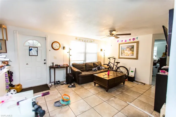 Living room with light tile patterned flooring and ceiling fan