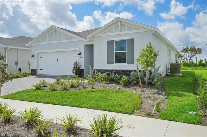 View of front of property featuring a front lawn and a garage
