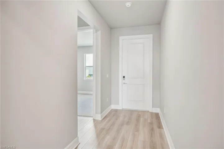 Hallway with light hardwood / wood-style floors