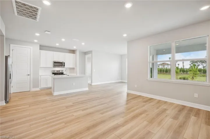 Unfurnished living room with light wood-type flooring and sink