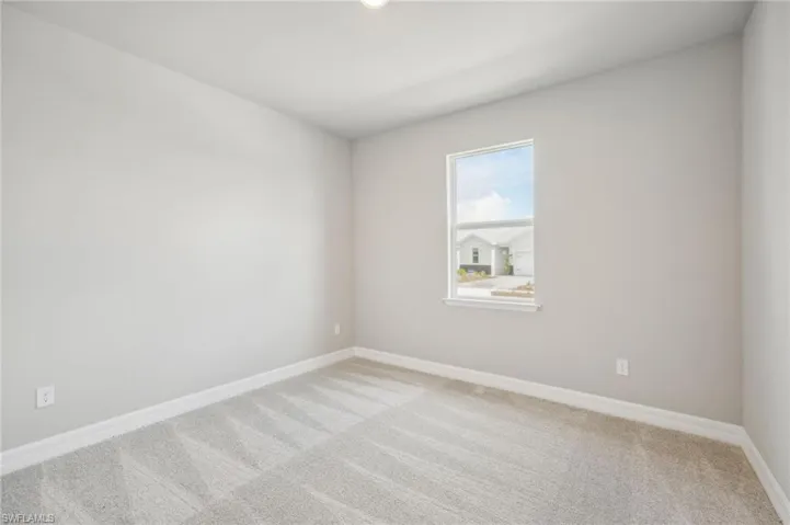 Spare room featuring light carpet