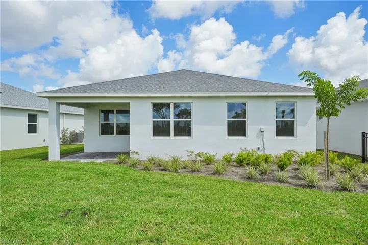 Back of property featuring a patio area and a yard
