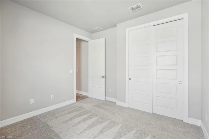Unfurnished bedroom featuring a closet and carpet flooring