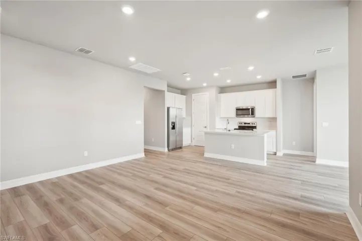 Unfurnished living room featuring light wood-type flooring and sink
