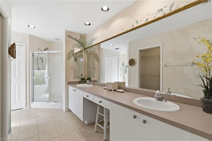 Dual sinks and walk in shower in primary bathroom