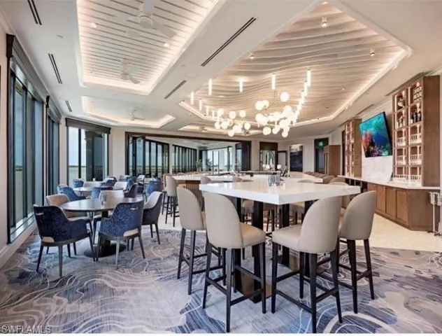 Dining area with a tray ceiling, a notable chandelier, and wood ceiling