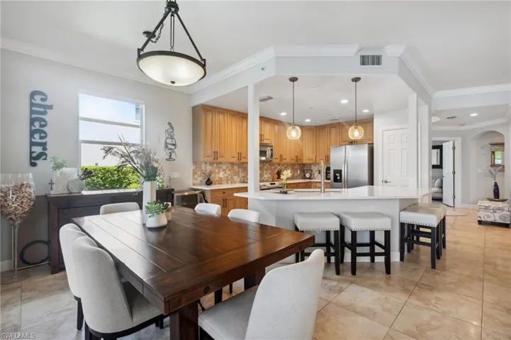 Tiled dining space featuring ornamental molding and sink
