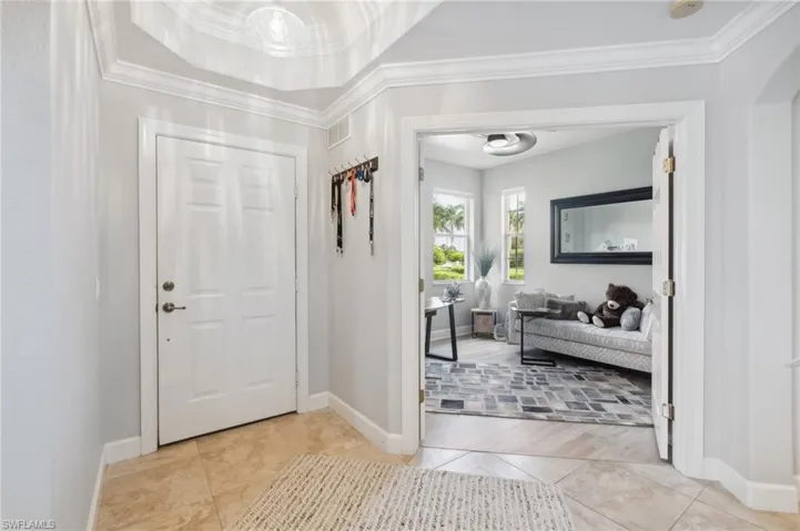 Foyer with crown molding and light wood-type flooring