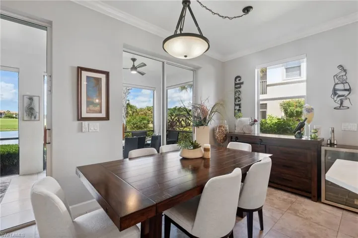 Dining room featuring light tile patterned flooring, plenty of natural light, ornamental molding, and ceiling fan