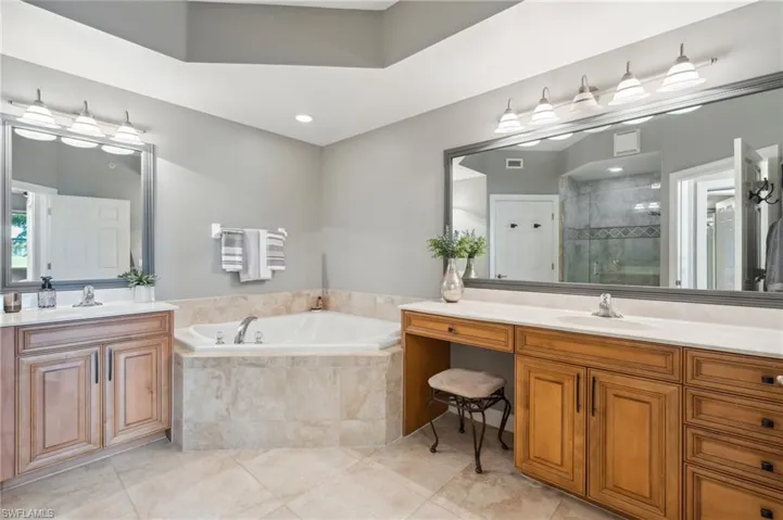 Bathroom with tile patterned flooring, vanity, and separate shower and tub