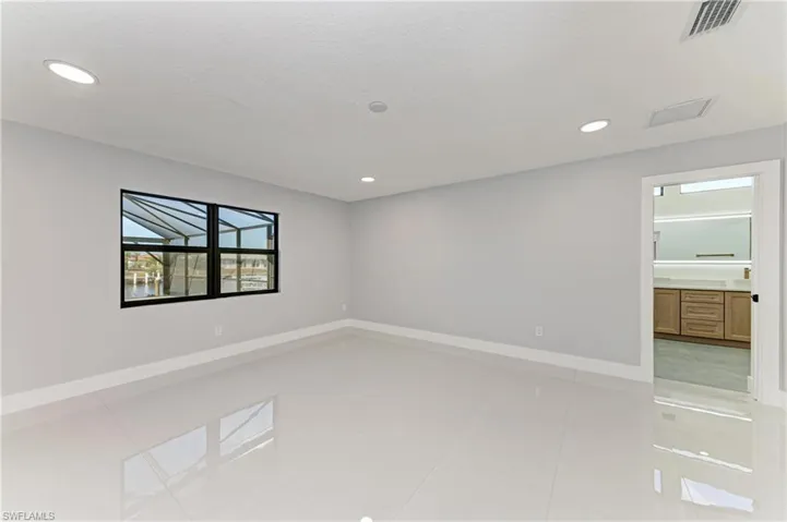 Empty room featuring light tile patterned flooring and recessed lighting