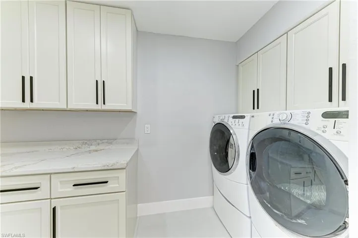 Laundry room with cabinet space and washer and clothes dryer