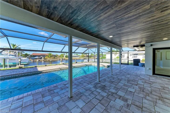 Swimming pool featuring a lanai, a patio, a sunroom, and a water view