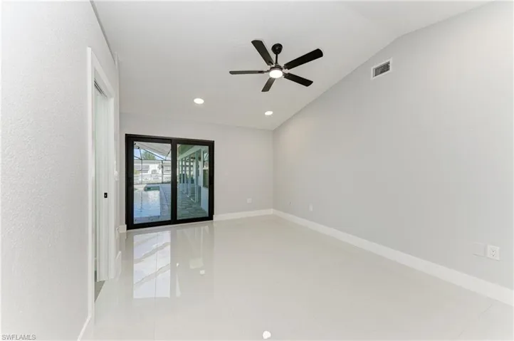 Unfurnished room with vaulted ceiling, ceiling fan, light tile patterned flooring, and recessed lighting