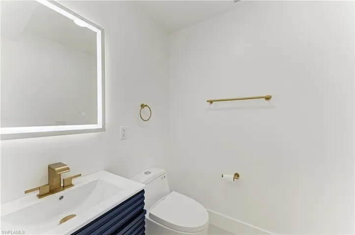 Half bathroom featuring vanity and toilet