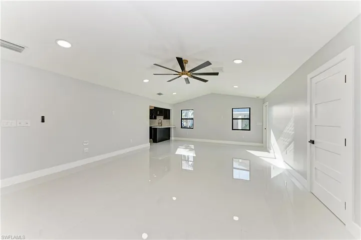 Unfurnished living room with lofted ceiling, light tile patterned floors, recessed lighting, and ceiling fan