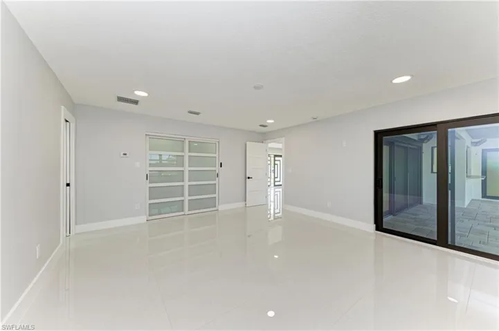 Empty room with recessed lighting and light tile patterned floors